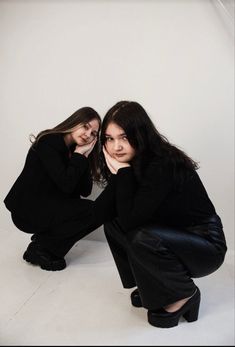 two women in black are posing for the camera