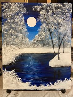 an easel with a painting on it that has snow and trees in the background