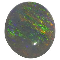 an oval black opal with green and yellow highlights