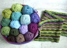 several skeins of yarn in a basket next to a knitted dishcloth