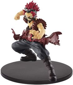 a figurine is shown on a white background with a black base and red hair