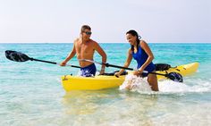 a man and woman are in the water with their kayaks