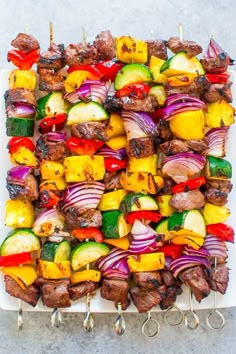 skewered meat and vegetables on a white platter