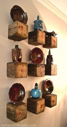 several pieces of wood are arranged on the wall with bowls and vases in them