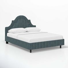 an upholstered bed with white pillows and blue pinstripe headboard, against a white background