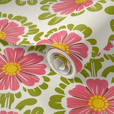 pink and green flowers on white fabric with yellow center ring in center, closeup