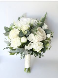 a bridal bouquet with white flowers and greenery