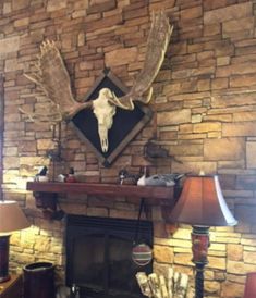 a living room filled with furniture and a fire place in front of a stone wall