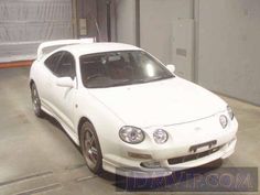 a white sports car parked in a garage