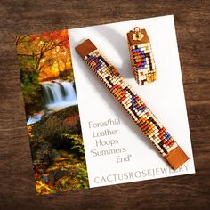 a wooden beaded bracelet next to a card with an image of a waterfall in the background