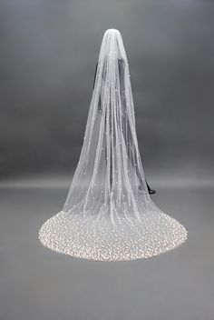 a white veil on top of a table with lights in the middle and an umbrella attached to it