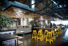 the interior of a restaurant with yellow stools