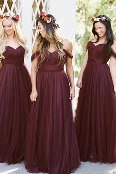 three women in long dresses with flower crowns on their head