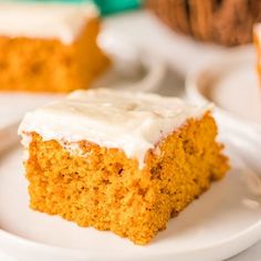 a piece of cake sitting on top of a white plate next to muffins