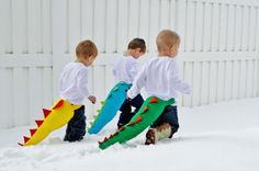 three young boys are playing in the snow with their toy alligators as they walk through the snow