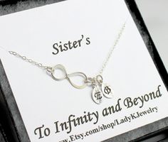 there is a silver necklace with a heart and an anchor on it in a box