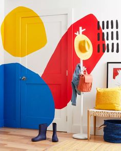 a room with colorful painted walls and flooring, including a coat rack on the door