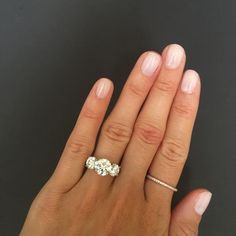 a woman's hand with a diamond ring on her left and an engagement band on her right