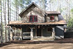 a house in the woods with red windows