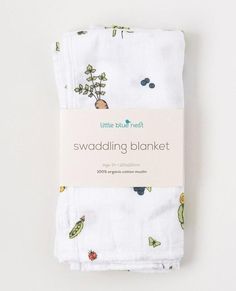 the little blue bird swadling blanket in white with cactus and pineapples on it