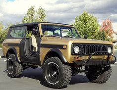 an old jeep is parked in a parking lot