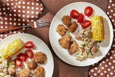 two plates filled with food on top of a brown and white polka dot table cloth