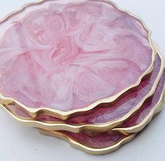 three pink and gold plates stacked on top of each other