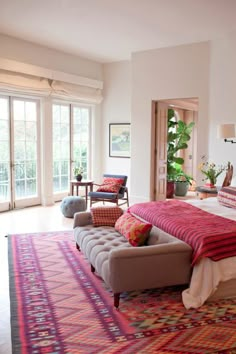 a large bed sitting in the middle of a living room next to a doorway with french doors