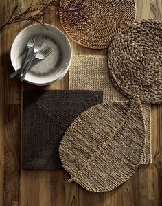 woven placemats, plates and forks on a wooden table