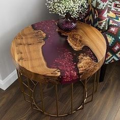 a wooden table with flowers on it next to a chair