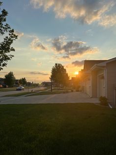 the sun is setting behind some houses