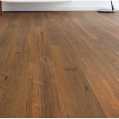 an empty room with wood floors and a white wall in the background, there is a coffee table on the far side