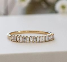 a gold ring with baguettes on it sitting on top of a white table