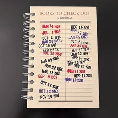 a spiral notebook with books to check out written in red, white and blue on it