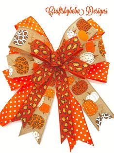 an orange and white bow with polka dot dots on the bottom is decorated with pumpkins