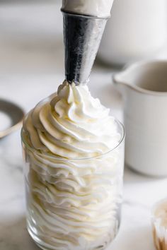 whipped cream being poured into a glass container