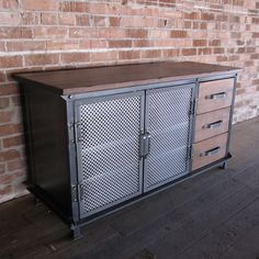 a metal cabinet sitting next to a brick wall