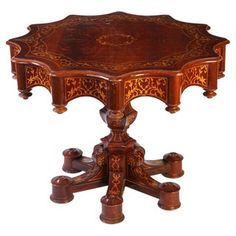 an ornately carved wooden table with four legs and one center piece at the top