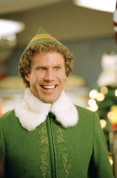 a man dressed in an elf costume smiles at the camera