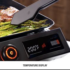 asparagus being cooked on top of an electric grill with the temperature display displayed