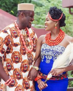 two people standing next to each other with beads on their heads and necklaces around their necks