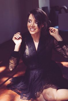 a woman sitting on the floor in a black dress