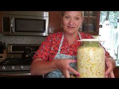 a woman holding a jar filled with food