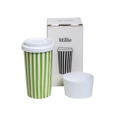 a green and white striped coffee cup next to a box