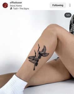 a woman's leg with a tattoo on it that has a bird in flight