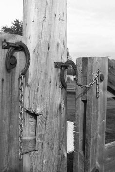 an old wooden gate with chains on it