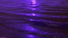 the sun is setting over the ocean with purple hues on the water and waves