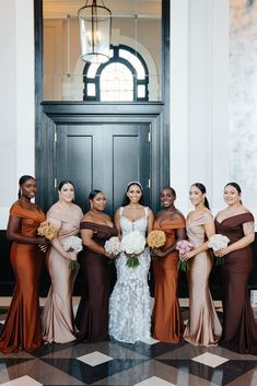 a group of women standing next to each other in front of a door wearing dresses