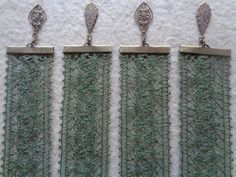 three pieces of green lace with silver clasps