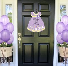 purple balloons are in front of a black door with it's a girl sign